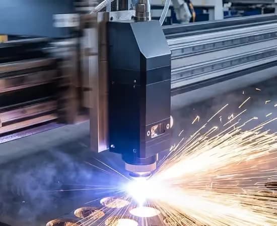 Cabeçote da fiber laser cortando chapa de aço, com a travessa de alumínio ao fundo e as fagulhas do corte