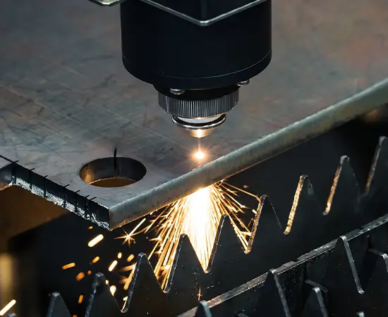 Cabeçote de corte da fiber laser cortando chapa de aço, com o bico sobre a chapa e as fagulhas do corte